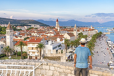 Man with hat admiring the old town from Karmelengo castle, in summer, Trogir, Split-Dalmatia county, Croatia, Europe