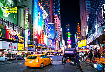 The bright lights of New York City's Times Square with an iconic yellow cab passing through, New York, United States of America, North America