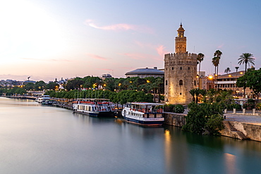 Sunset at Torre del Oro (Tower of Gold), a watchtower on the bank of the Guadalquivir River in Seville, Andalusia, Spain, Europe