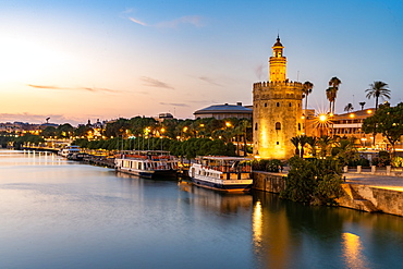 Sunset at Torre del Oro (Tower of Gold), a watchtower on the bank of the Guadalquivir River in Seville, Andalusia, Spain, Europe