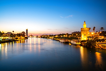 Sunset at Torre del Oro (Tower of Gold), a watchtower on the bank of the Guadalquivir River in Seville, Andalusia, Spain, Europe