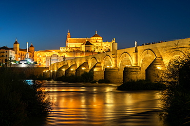 The Roman Bridge (Puente Romano) and The Great Mosque of Cordoba lit up during evening twilight at dusk, UNESCO World Heritage Site, Cordoba, Andalusia, Spain, Europe