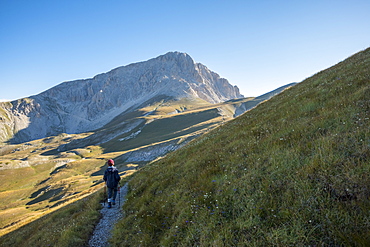 Hiker on the path to the summit of peak Corno Grande, Gran Sasso e Monti della Laga National Park, Abruzzo, Italy, Europe