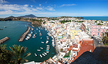 panoramic view of Coricella town, sea and castle on beautiful Procida island with colorful houses in sunny summer day Italy