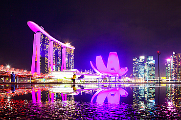 SINGAPORE, SINGAPORE - MARCH 2019: Skyline of Singapore Marina Bay at night with Marina Bay sands and Art Science museum reflecting in a pond after rain. Vibrant night scene