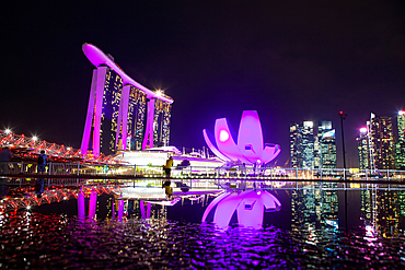 SINGAPORE, SINGAPORE - MARCH 2019: Skyline of Singapore Marina Bay at night with Marina Bay sands and Art Science museum reflecting in a pond after rain. Vibrant night scene