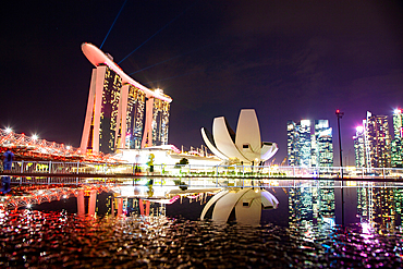 SINGAPORE, SINGAPORE - MARCH 2019: Skyline of Singapore Marina Bay at night with Marina Bay sands and Art Science museum reflecting in a pond after rain. Vibrant night scene