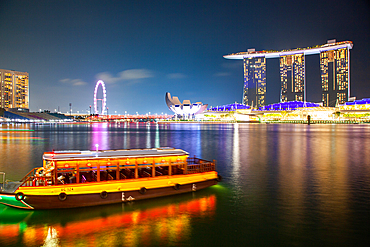 SINGAPORE, SINGAPORE - MARCH 2019: Skyline of Singapore Marina Bay at night with Marina Bay sands, Art Science museum and tourist boats