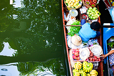 floating market - top view of boat full of fresh fruits on sale