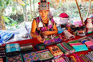 Akha woman selling her goods in Baan Tong Luang eco village near Chiangmai,Thailand. Akha people arrived to Thailand from Myanmar and now live in villages across northern Thailand selling their handicraft to tourists.