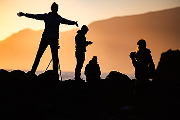 silhouettes of tourist photographers on the beach