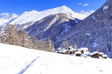 A trail in the snow leads to the traditional huts of Blatten, Zermatt, Canton of Valais (Wallis), Switzerland, Europe