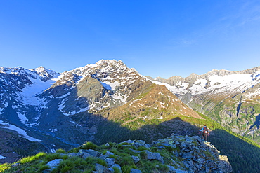 A hiker looks at Mount Disgrazia from above, Chiareggio valley, Valmalenco, Valtellina, Lombardy, Italy, Europe