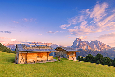 Traditional huts at sunset with Sassolungo and Sella Group in the background, Gardena Valley, South Tyrol, Dolomites, Italy, Europe