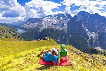 Tourists look towards Viel del Pan Refuge with Marmolada in the background, Pordoi Pass, Fassa Valley, Trentino, Dolomites, Italy, Europe