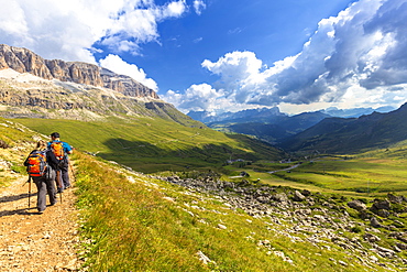 Hikers walk on a path near Pordoi Pass, Fassa Valley, Trentino, Dolomites, Italy, Europe