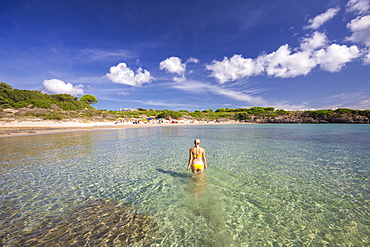 A girl in swimsuit walks in the water, La Bobba Beach, San Pietro Island, Sud Sardegna province, Sardinia, Italy, Mediterranean, Europe