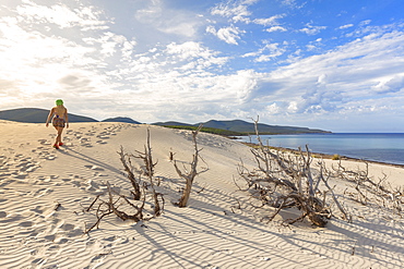 A girl walks on the sand dune of Is Arenas Biancas, Teulada, Cagliari province, Sardinia, Italy, Mediterranean, Europe