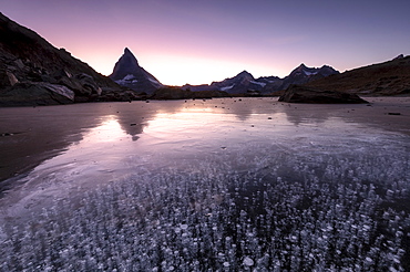 Frozen Riffelsee lake by Matterhorn at sunset in Switzerland, Europe