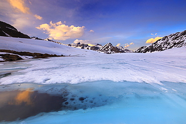 Sunset during thaw at the Malghera Lake, Valtellina, Lombardy, Italy, Europe