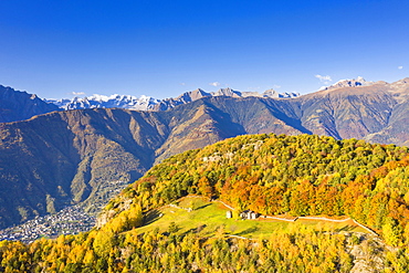 Small group of huts in autumn colors with view over the mountains, Valtellina, Lombardy, Italy, Europe