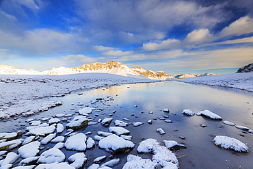 Winter scenery with frozen alpine lake, Stelvio Pass, Valtellina, Lombardy, Italy, Europe