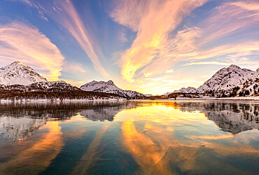 Colors of sunset reflected on the icy surface of Lake Sils, Engadine Valley, Graubunden, Switzerland, Europe