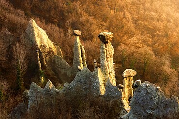 Sunlight illuminates earth pyramids (rock chimneys) of Zone, Zone, Brescia province, Lombardy, Italy, Europe