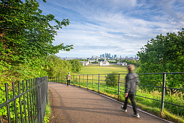 Tourist walking in Greenwich Park with Canary Wharf in the background, London, England, United Kingdom, Europe