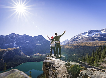 Hiker couple at the Alpine circuit trail looking down the Lake O'Hara, Yoho National Park, UNESCO World Heritage Site, Canadian Rockies, British Columbia, Canada, North America