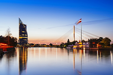 Suspension bridge with huge Latvian flag from AB dam at sunset, Riga, Latvia, Europe