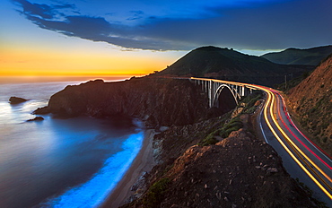 Sunset over Bixby Creek Bridge and car trail lights, Big Sur, California, United States of America, North America