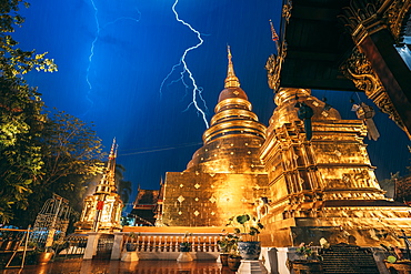 Lightning and thunderstorm over Wat Phra Singh Gold Temple at night, Chiang Mai, Thailand, Southeast Asia, Asia