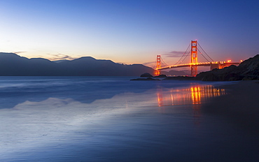 Soft flowing water reflects the beautiful Golden Gate Bridge from Baker Beach, San Francisco, California, United States of America, North America