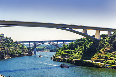 View of three bridges over Douro River with tourist ships in front of Infante D. Henrique, Maria Pia and St. John bridges, Porto, Portugal, Europe