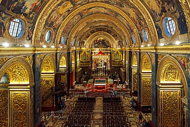 Panoramic interior view of Roman Catholic St. John Co-Cathedral with golden Maltese cross symbols on arches, Valletta, Malta, Europe