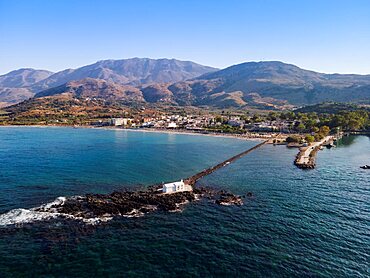 Mediterranean terrain Greek beach landscape drone shot with bathers at Georgioupoli Crete island with sea beds and umbrellas.