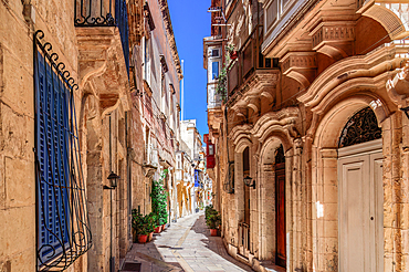 Traditional Maltese limestone buildings with coloured balconies in the vibrant alleys of the old city of Birgu (Citta Vittoriosa), Malta, Mediterranean, Europe