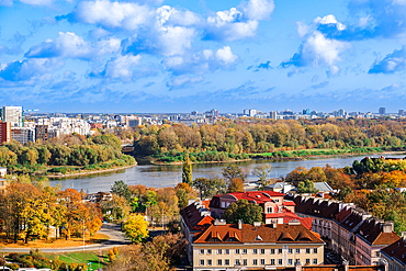 Landscape panoramic view of city skyline with houses and skyscrapers under a blue sky with clouds and greenery around Vistula River with Praga borough visible, Warsaw, Poland, Europe