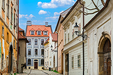 Historic low rise buildings with traditional architecture around a cobblestone street in the Old Town of Bratislava, Slovakia, Europe