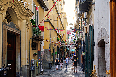 Alley with crowd on a cobblestone street around low-rise historic buildings, Salerno, Campania, Italy, Europe