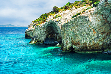 Natural cave formation on a rocky hill with green plantation stretching to the sea, Zakynthos, Ionian Islands, Greek Islands, Greece, Europe