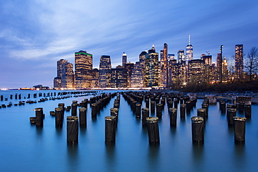 Lower Manhattan skyline with wooden posts from an old pier in the foreground. New York City, New York, United States of America, North America