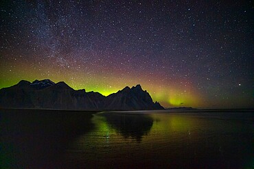 Northern Lights (Aurora Borealis) and Milky Way above Vestrahorn mountain, reflecting in water, Stokksnes peninsula, Southeast Iceland, Polar Regions