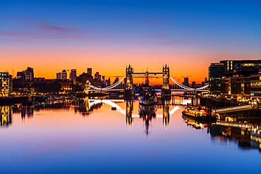 Tower Bridge, HMS Belfast and reflections in a still River Thames at sunrise, London, England, United Kingdom, Europe