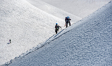 Climbers descending down a steep ridge from the Aiguille du Midi to the valley Blanche below, Chamonix, Haute Savoie, Rhone Alpes, France, Europe