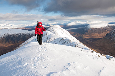 A female walker approaching the summit of Stob Dubh on Buchaille Etive Beag on a crisp winter day, Highlands, Scotland, United Kingdom, Europe