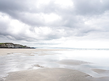 Cloud formations and wet sand on the vast expanse of beach at Sandymouth, looking towards Bude, Cornwall, England, United Kingdom, Europe