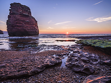 Dawn on the beach with one of the majestic sea stacks at Ladram Bay, Sidmouth, Devon, England, United Kingdom, Europe