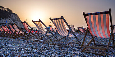 Fishing boats and deckchairs on the popular pebble beach at Beer near Seaton, Devon, England, United Kingdom, Europe